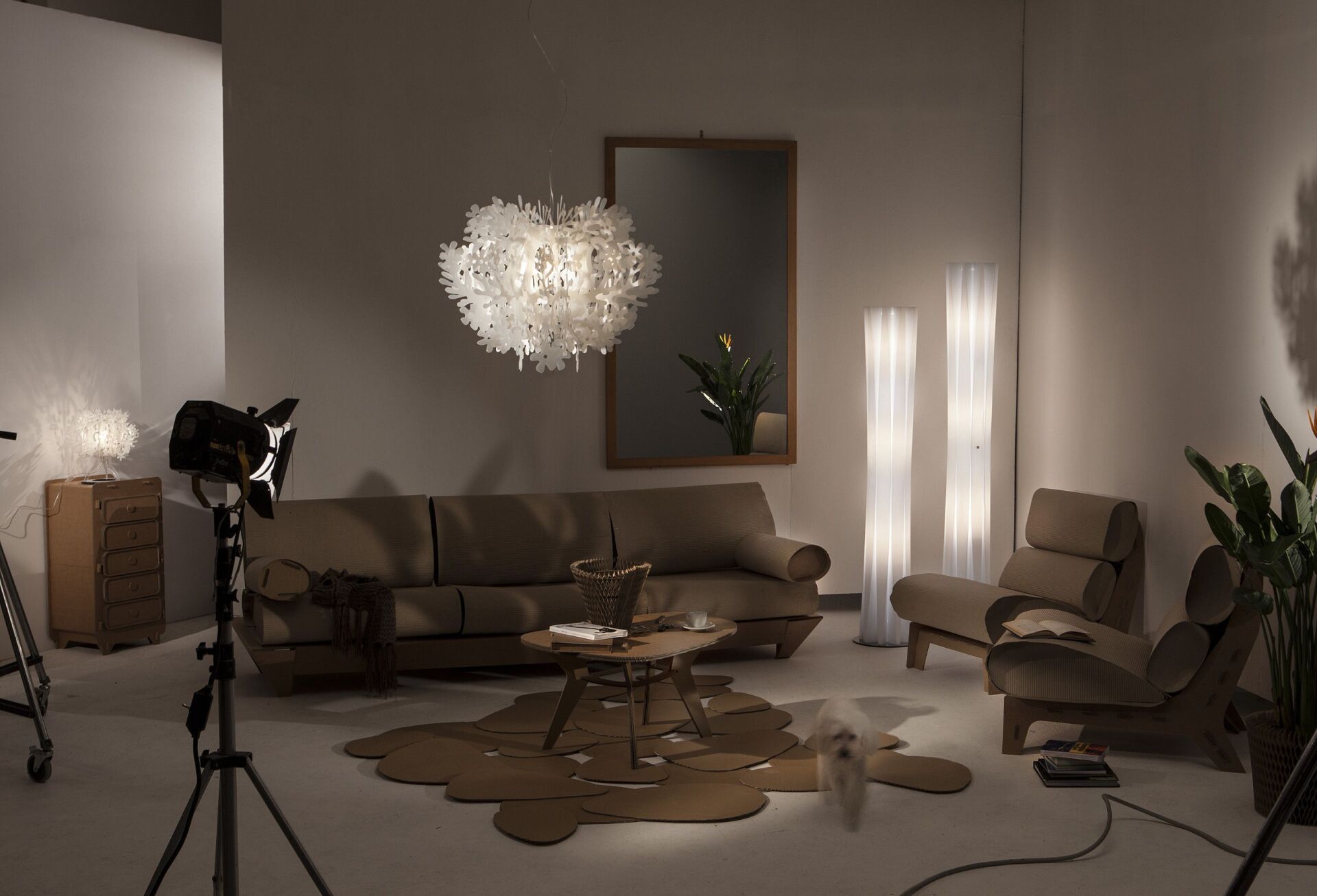 Ein Wohnzimmer mit Couch, Sessel, Tisch und Lampe.