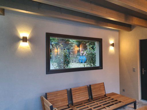 Ein Wohnzimmer mit Couch, Sesseln und großem Fenster.