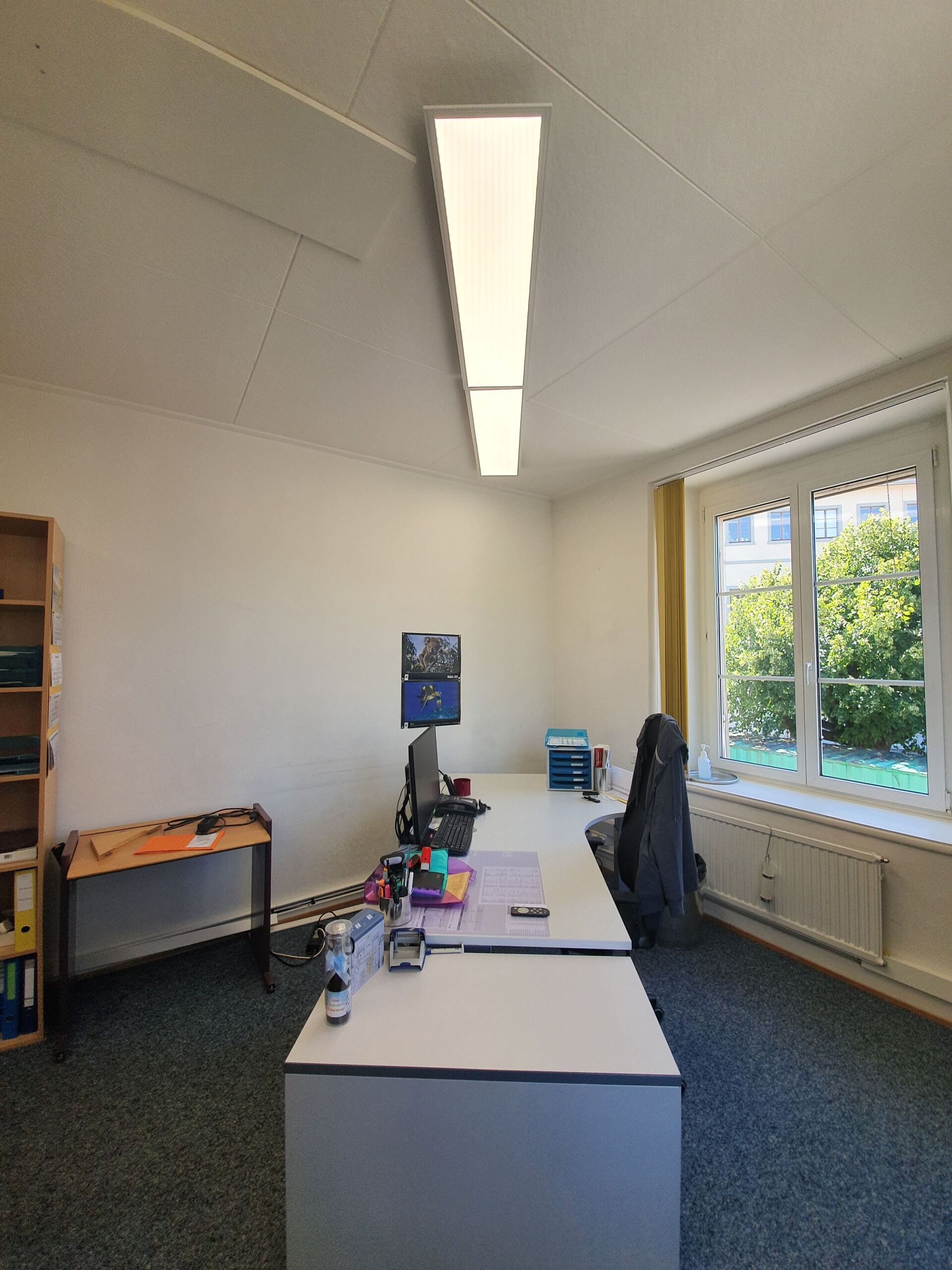 Ein kleines Büro mit zwei Schreibtischen und einem Fenster