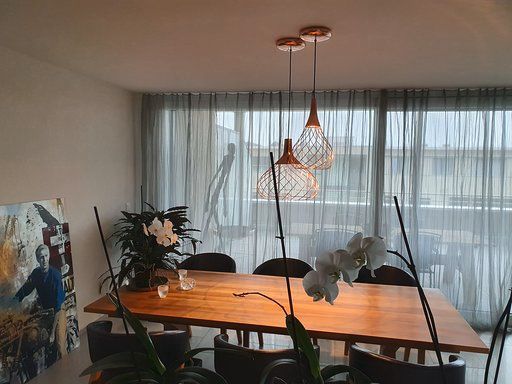 Ein Esszimmer mit einem Holztisch und Stühlen und einem Gemälde an der Wand.