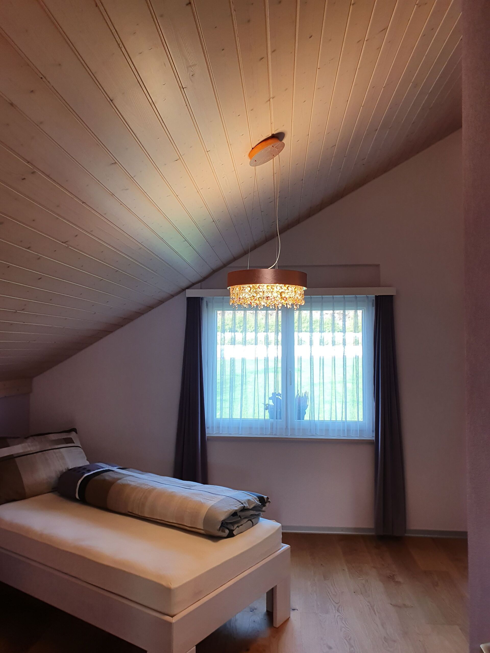 Ein Schlafzimmer mit einem Bett und einem Fenster mit lila Vorhängen