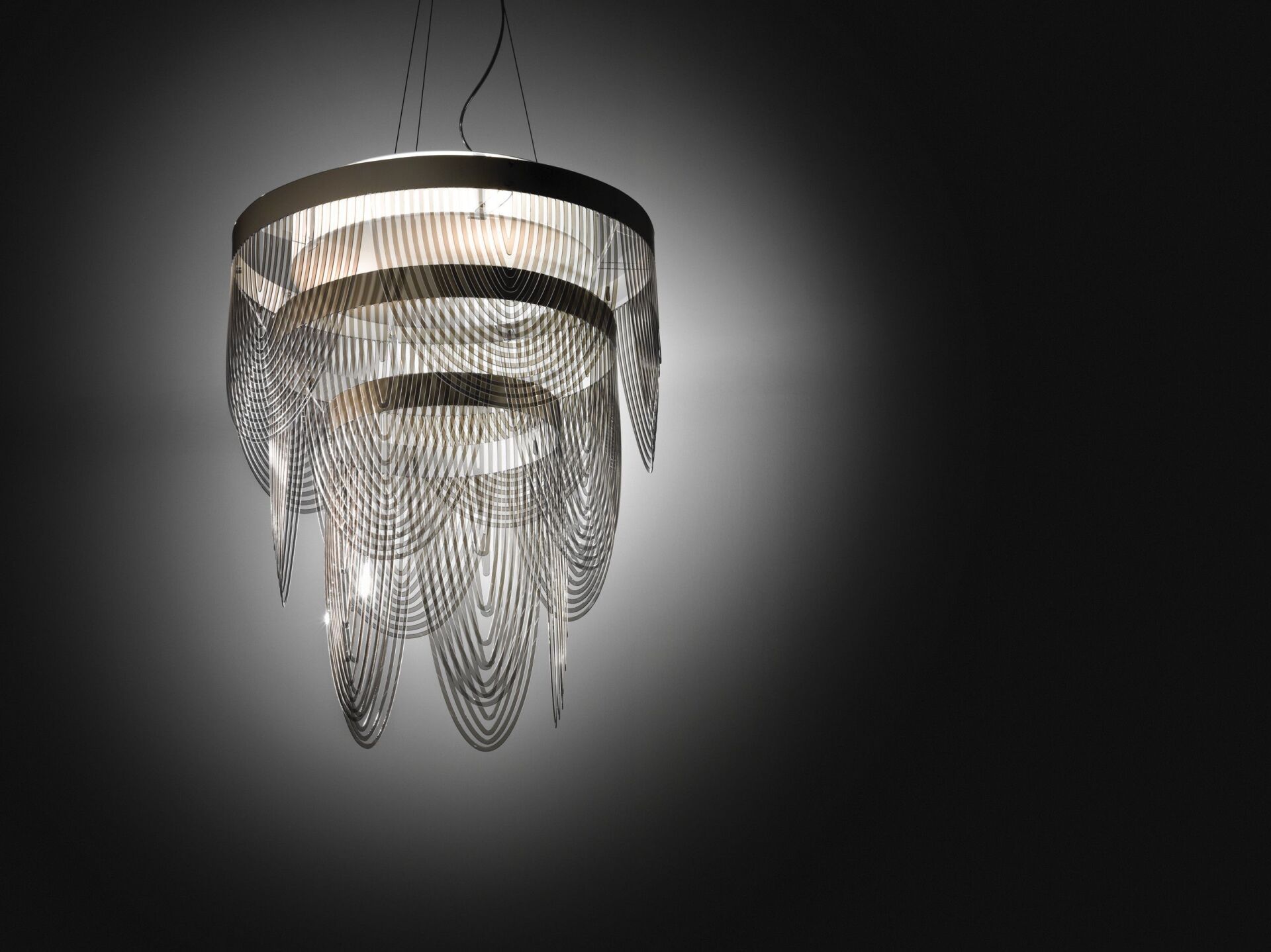 In einem dunklen Raum hängt ein Kronleuchter von der Decke.