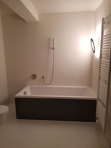 Ein Badezimmer mit Badewanne, Toilette und Handtuchhalter.