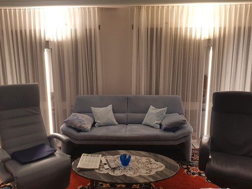 Im Wohnzimmer gibt es eine Couch und zwei Sessel.