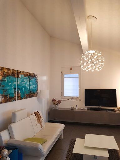 Ein Wohnzimmer mit Couch, Tisch und Fernseher.