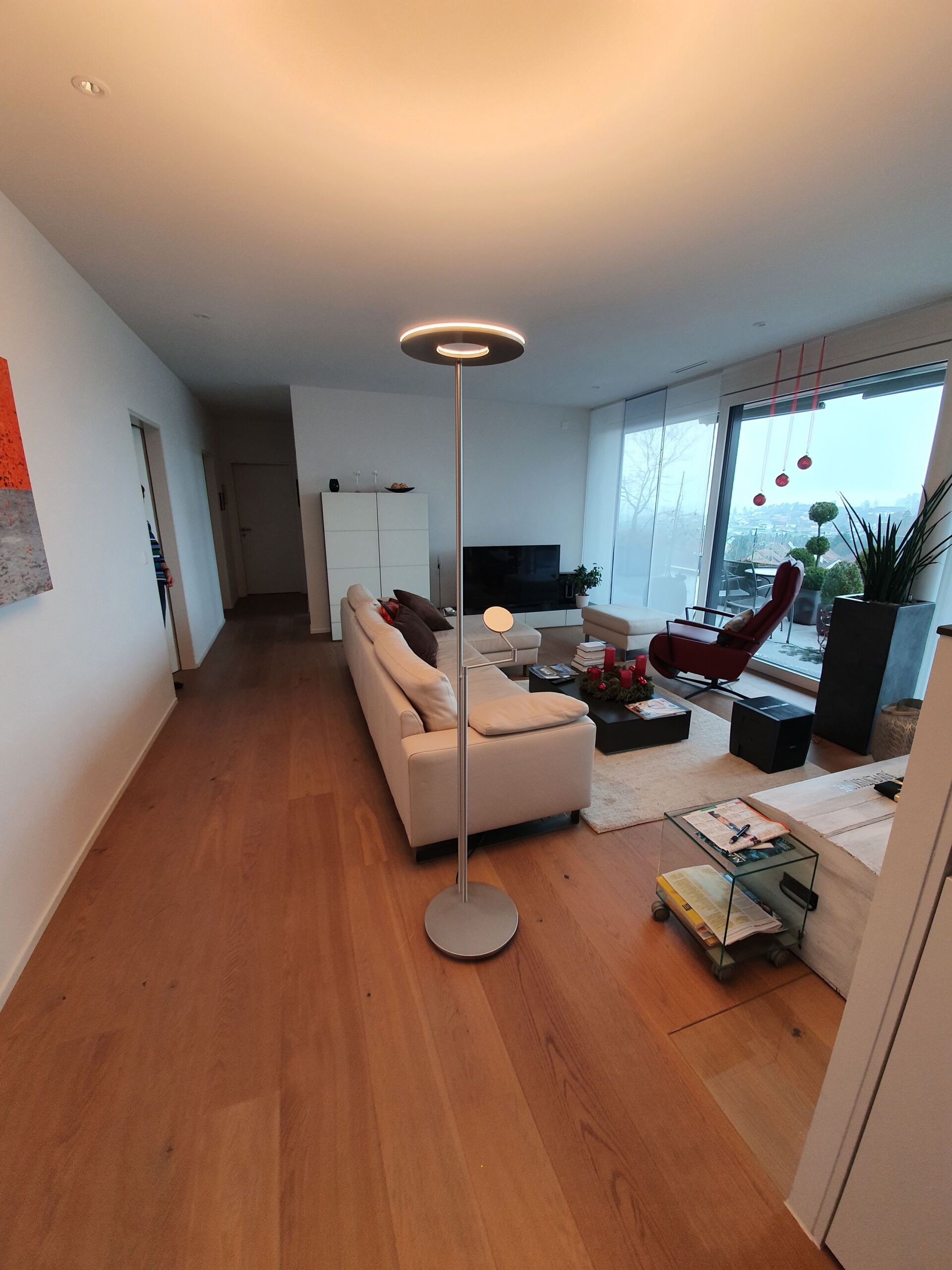 Ein Wohnzimmer mit einer Couch und einer Lampe auf dem Boden