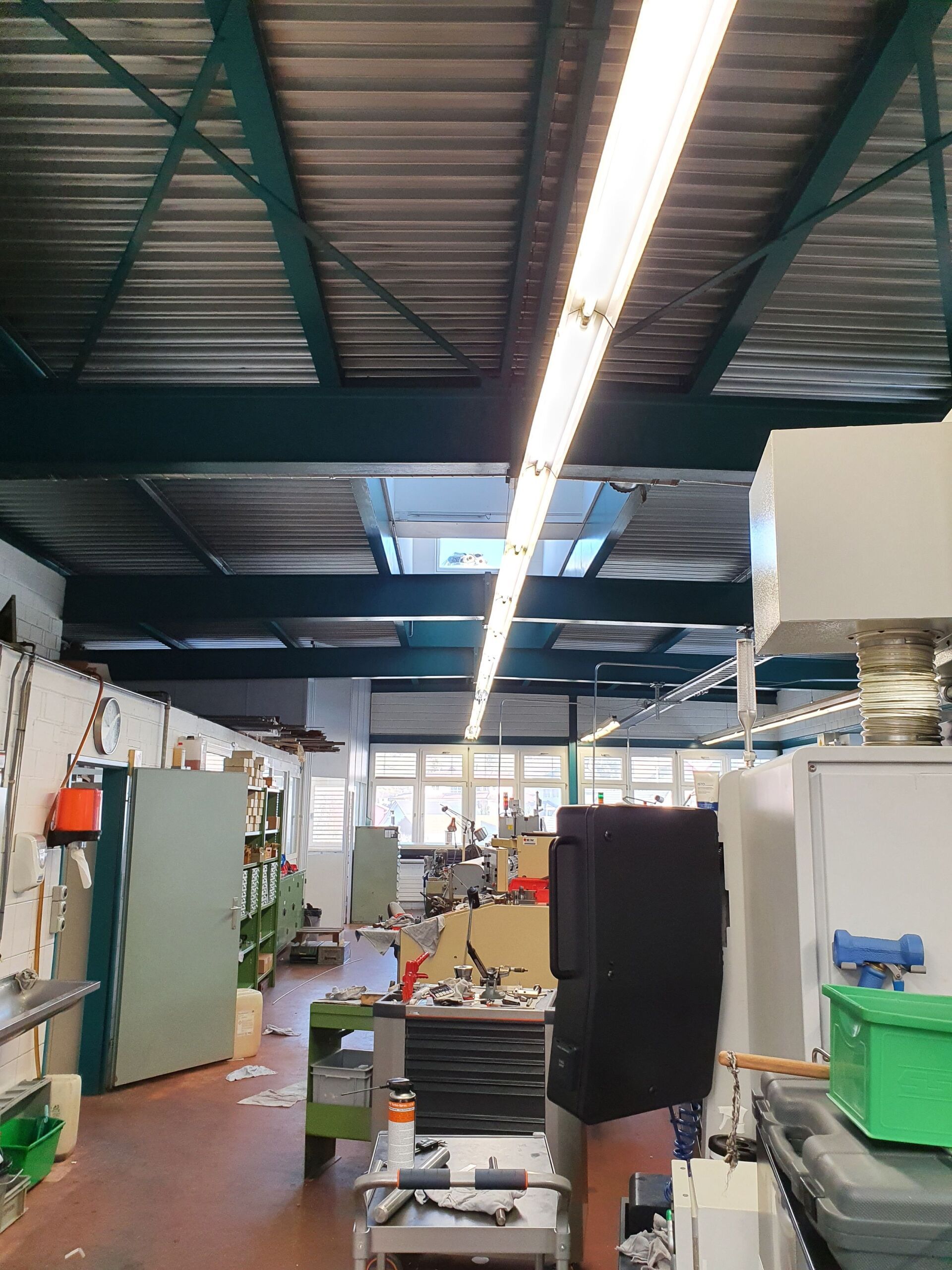 Ein großer Raum mit viel Ausrüstung und einer grünen Kiste auf dem Boden