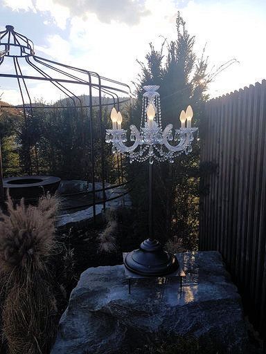 Ein Kronleuchter sitzt auf einem Felsen in einem Garten