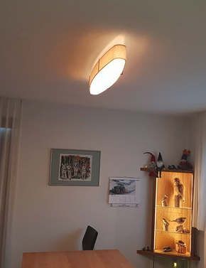 Ein Wohnzimmer mit einem Tisch und einer Deckenleuchte.