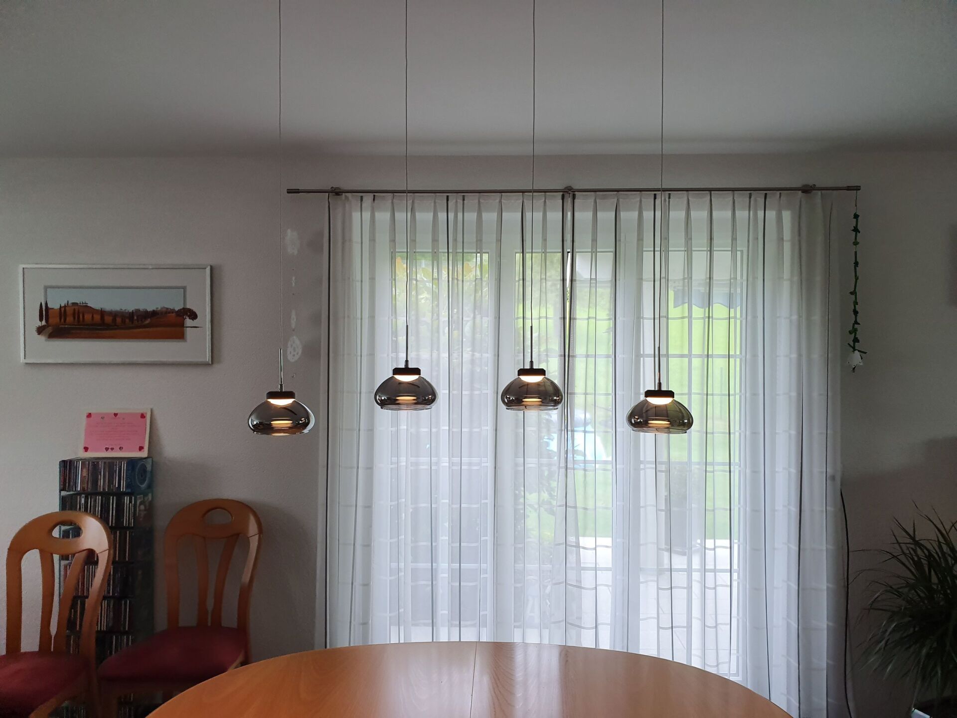 Ein Esszimmer mit Tisch und Stühlen und weißen Vorhängen