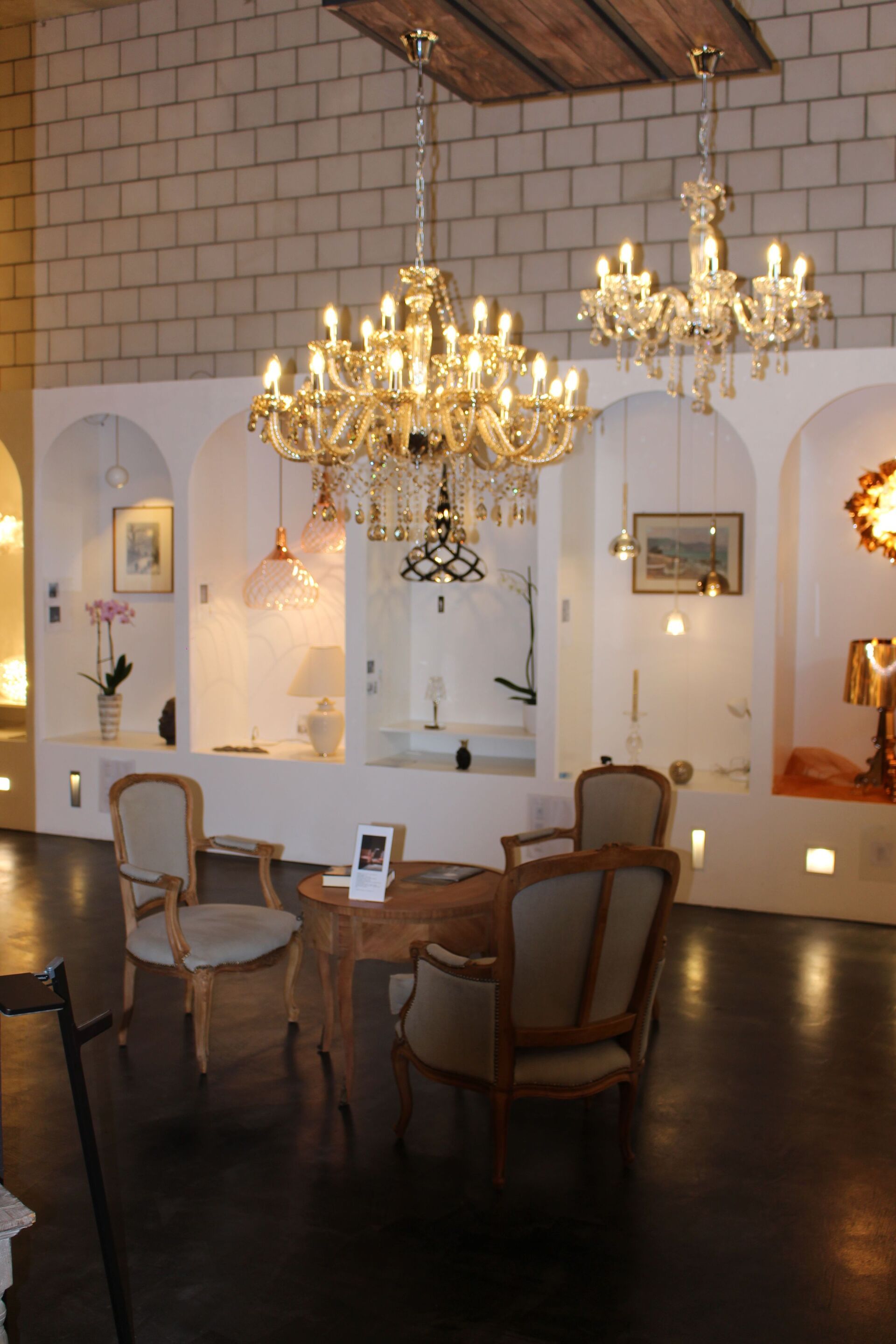 Ein Raum mit einem Tisch, Stühlen und Kronleuchtern, die von der Decke hängen