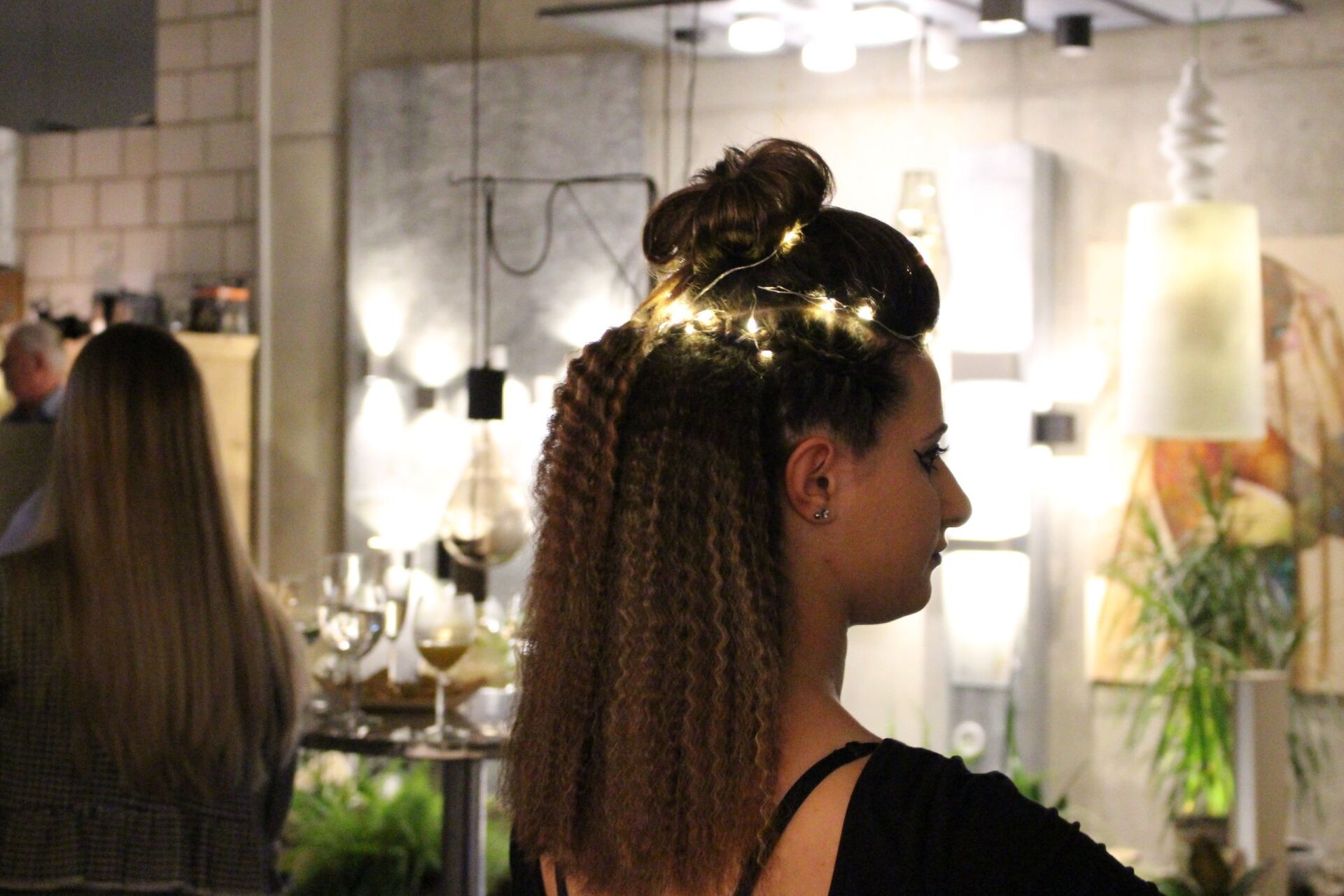 Eine Frau mit Lichtern im Haar steht in einem Raum.