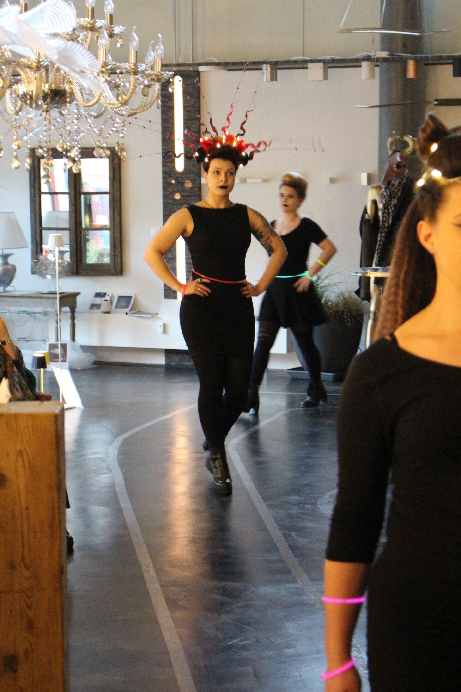 Eine Frau in einem schwarzen Kleid geht in einen Raum