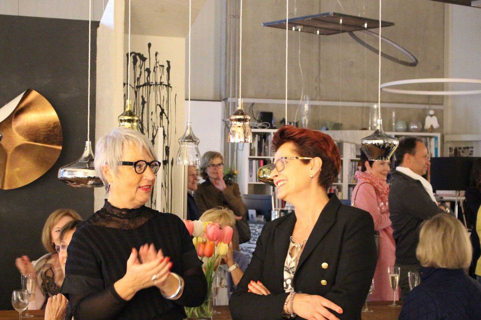 Zwei Frauen stehen nebeneinander in einem Raum und unterhalten sich.