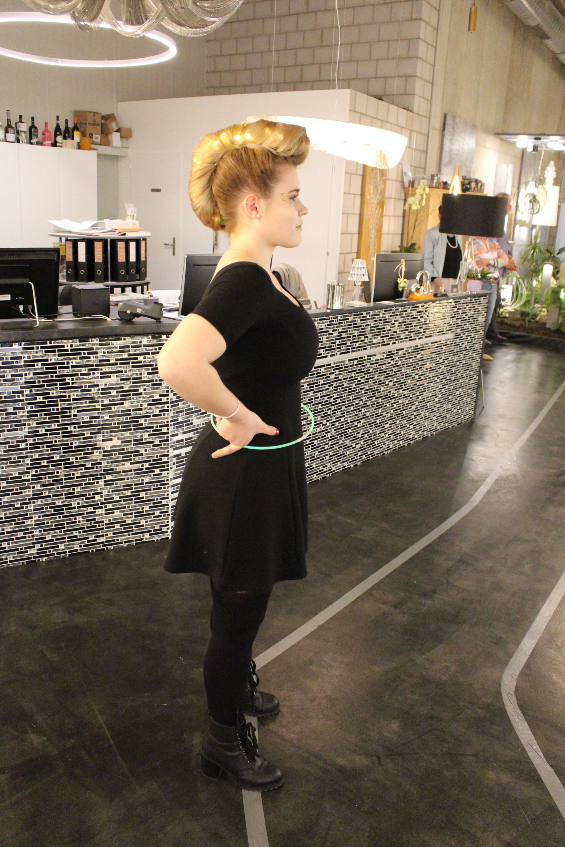 Eine Frau in einem schwarzen Kleid steht in einem Raum