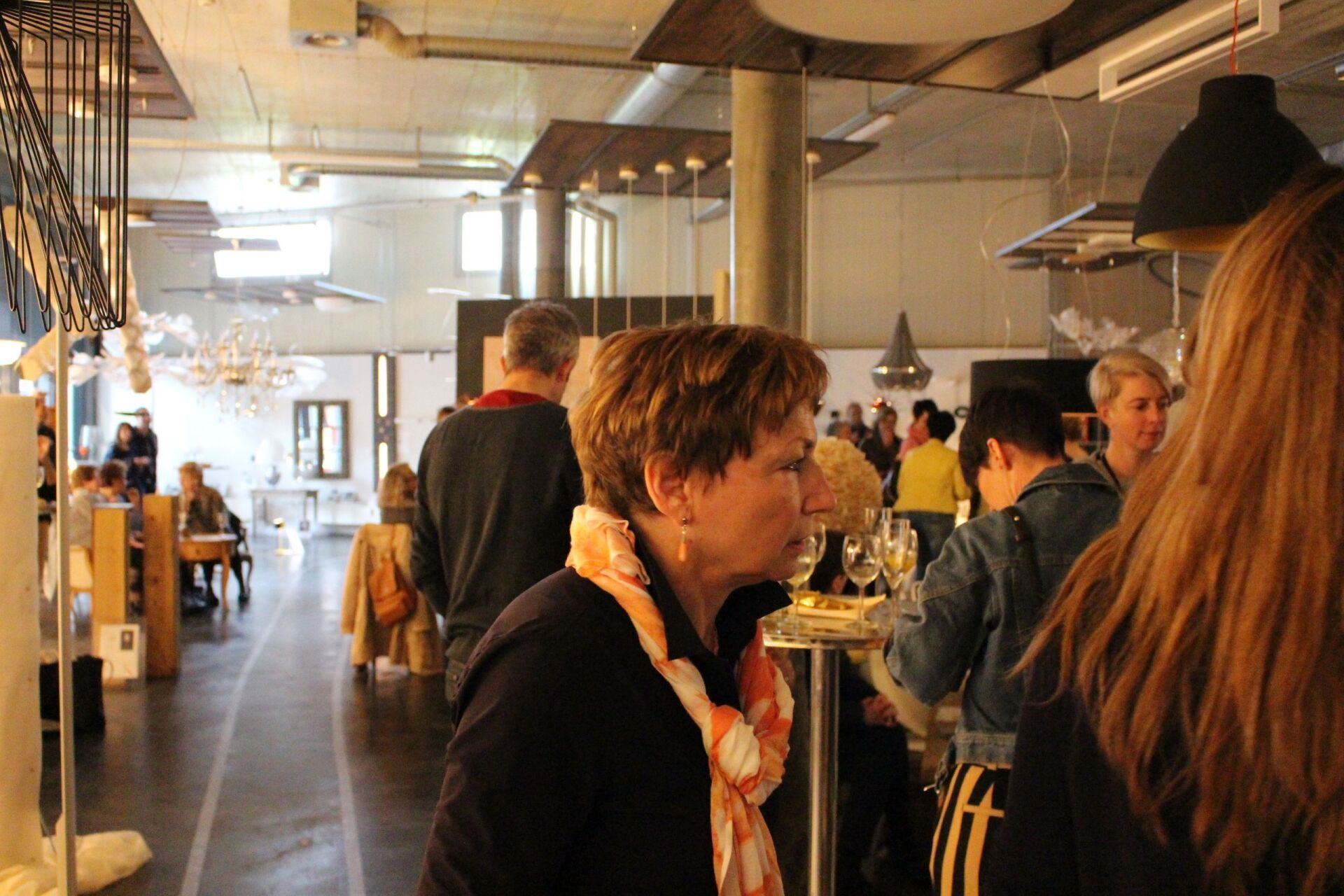 Eine Frau mit Kopftuch steht in einem überfüllten Raum