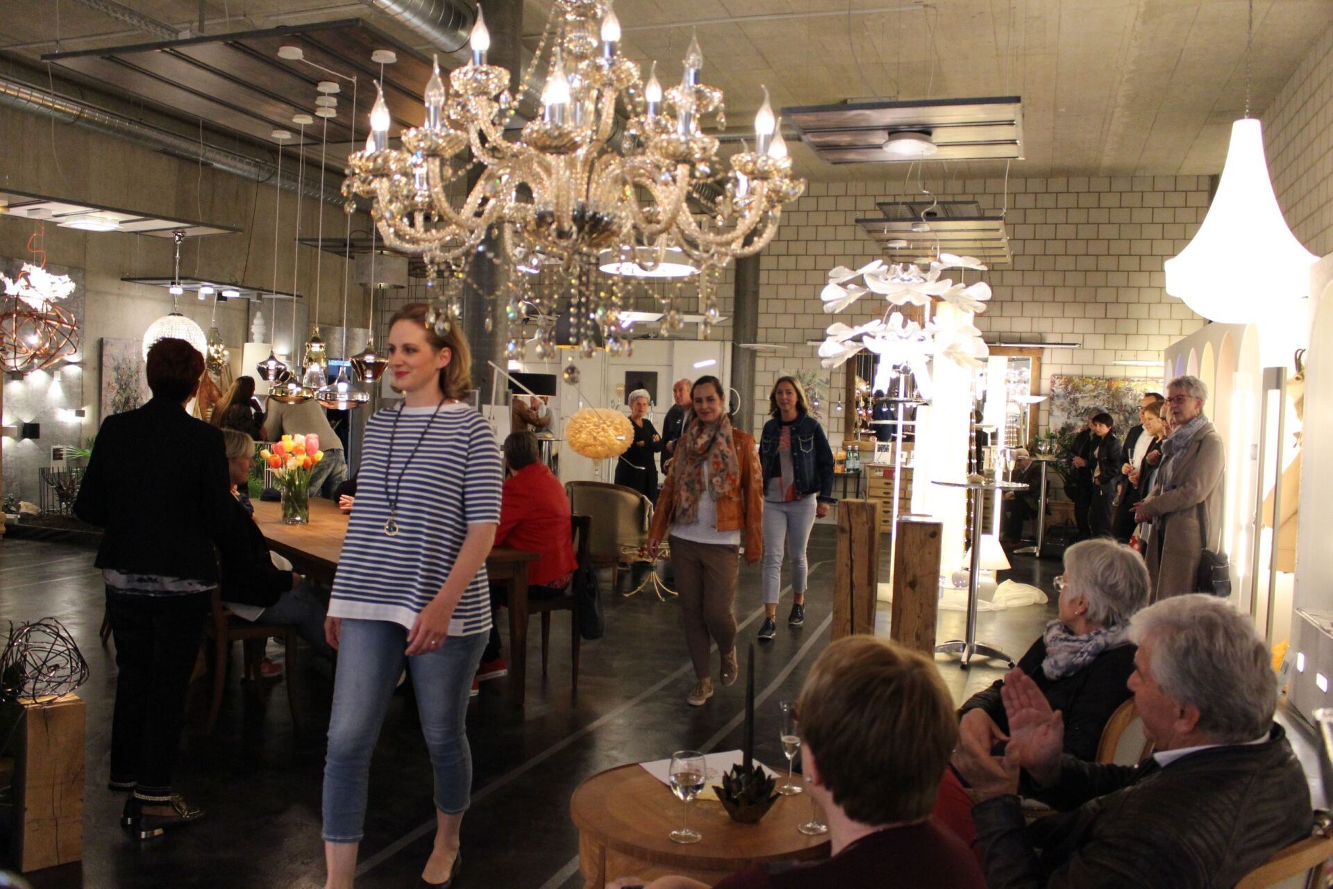 Eine Frau geht in einen Raum , von dessen Decke ein Kronleuchter hängt.