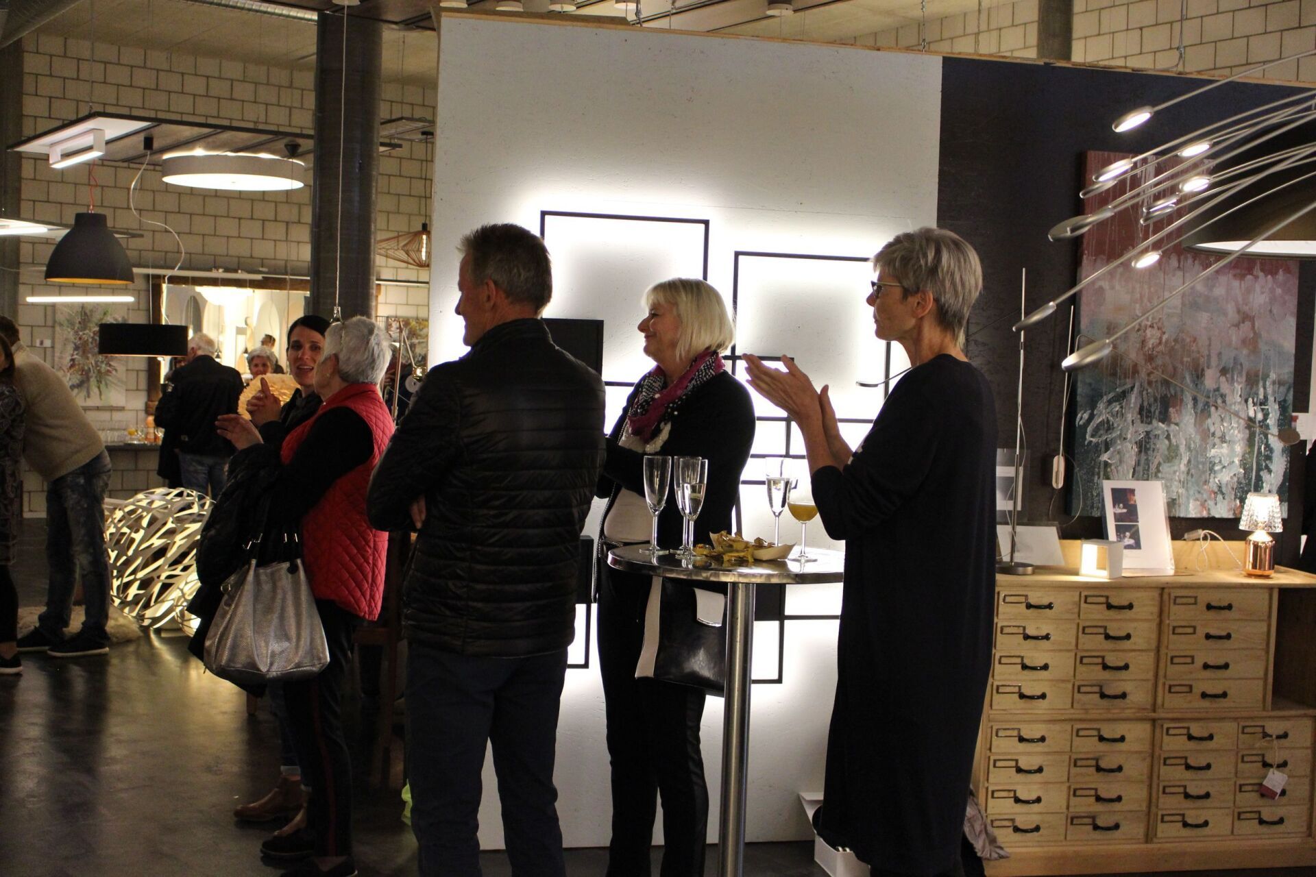 Eine Gruppe von Menschen steht in einem Raum und unterhält sich