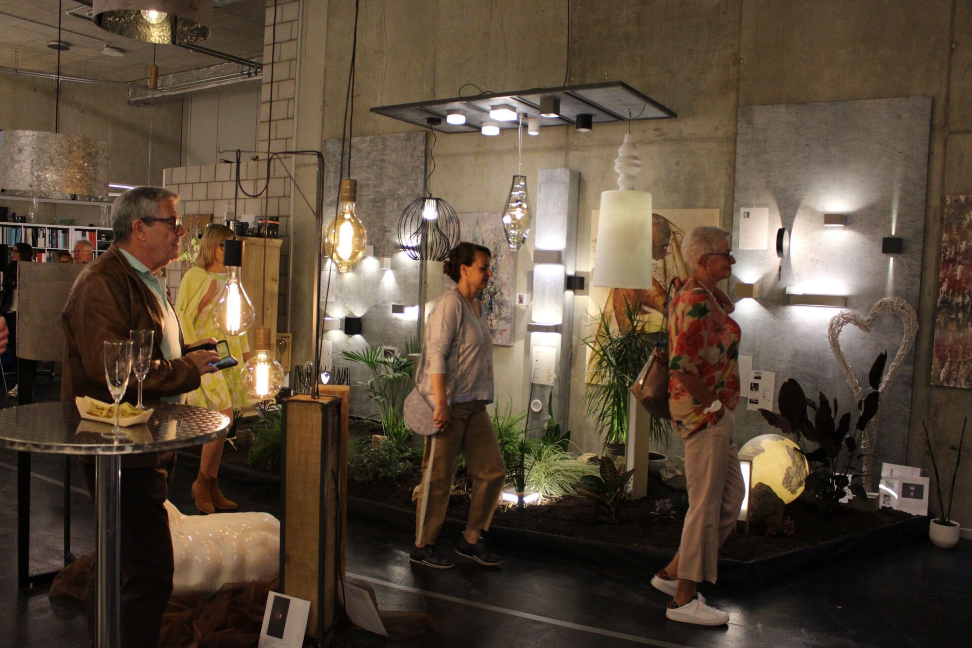 Eine Gruppe von Menschen steht in einem Raum und betrachtet ein Lichterspiel.