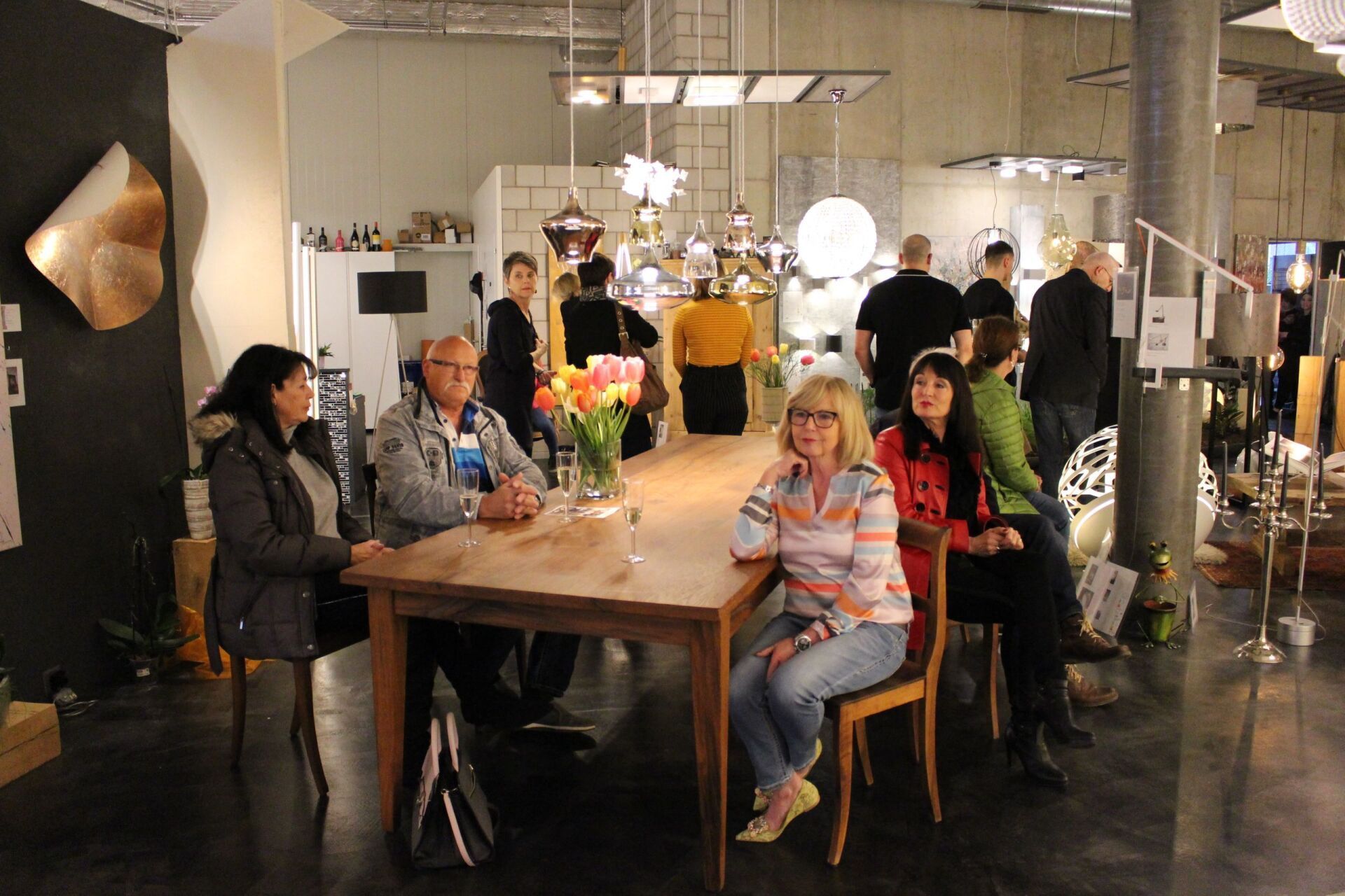 Eine Gruppe von Menschen sitzt in einem Raum um einen Tisch herum