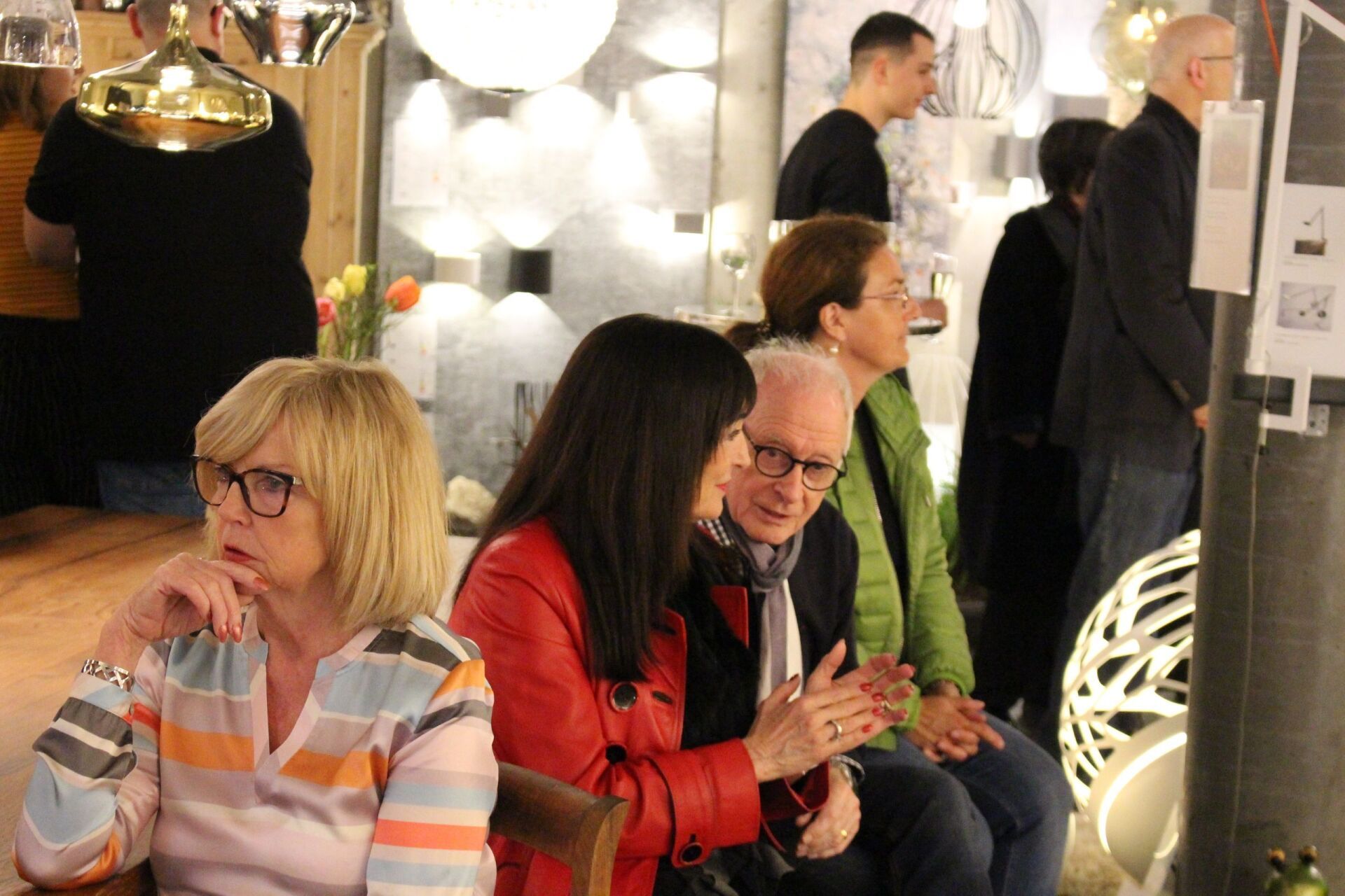 Eine Gruppe von Menschen sitzt in einem Raum und unterhält sich