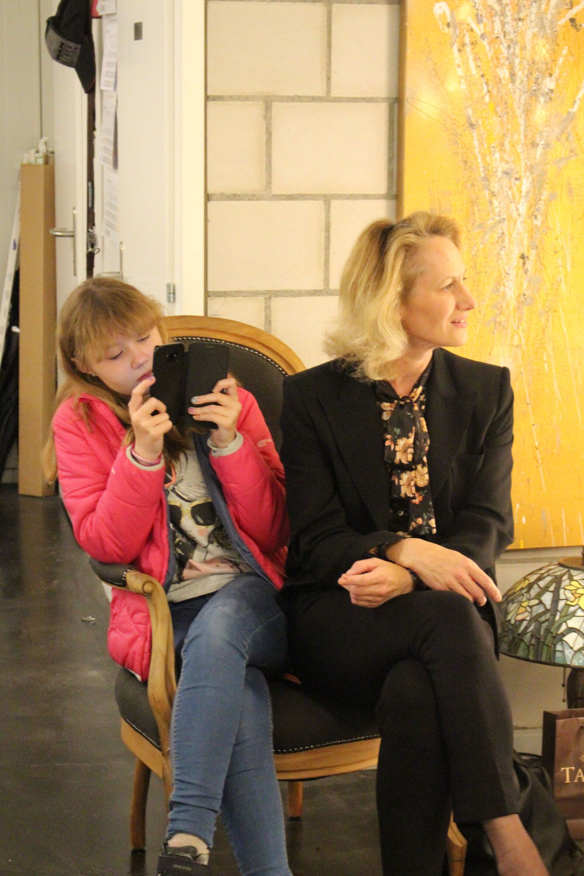 Eine Frau und ein kleines Mädchen sitzen auf Stühlen.