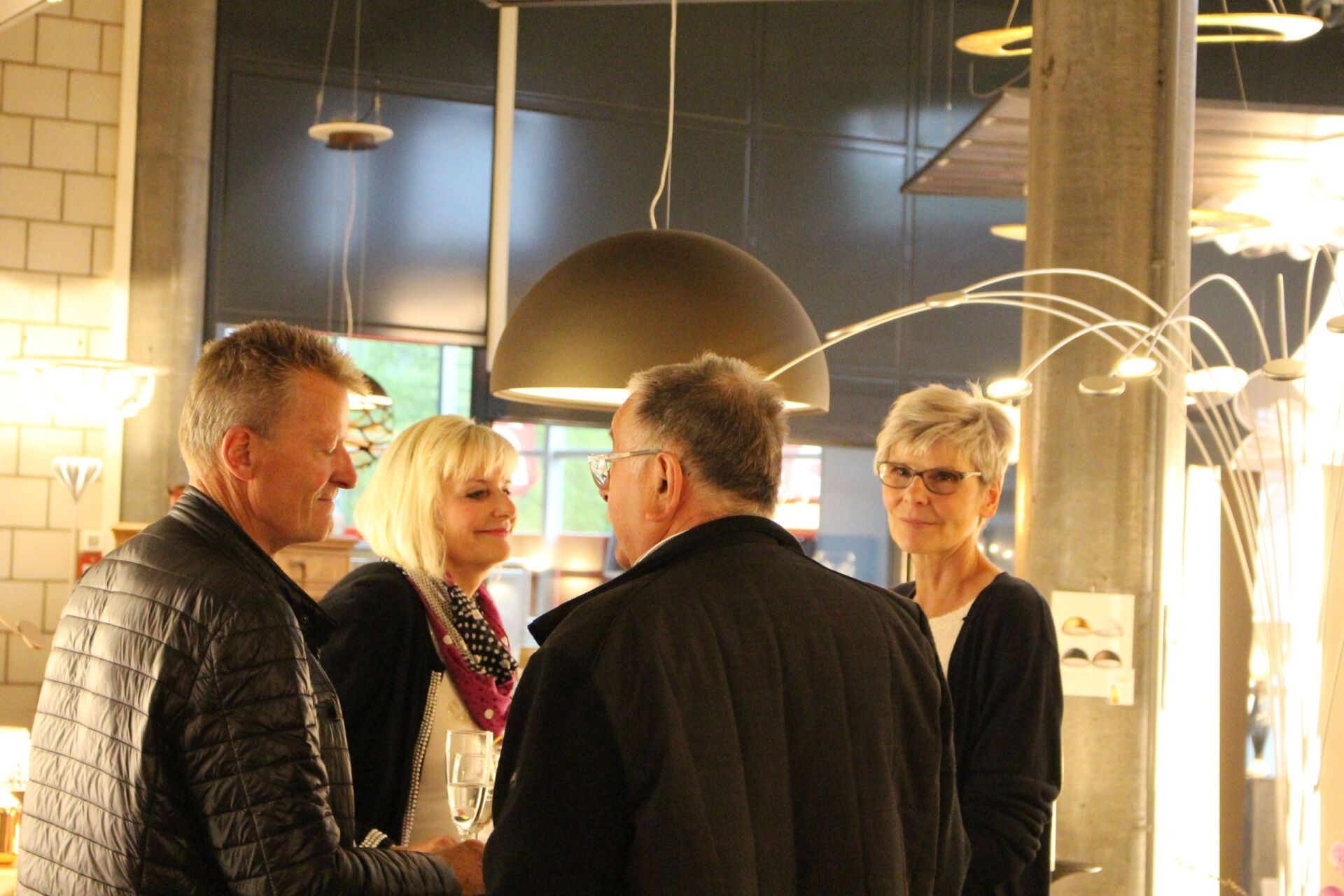 Eine Gruppe von Leuten steht in einem Raum und unterhält sich.