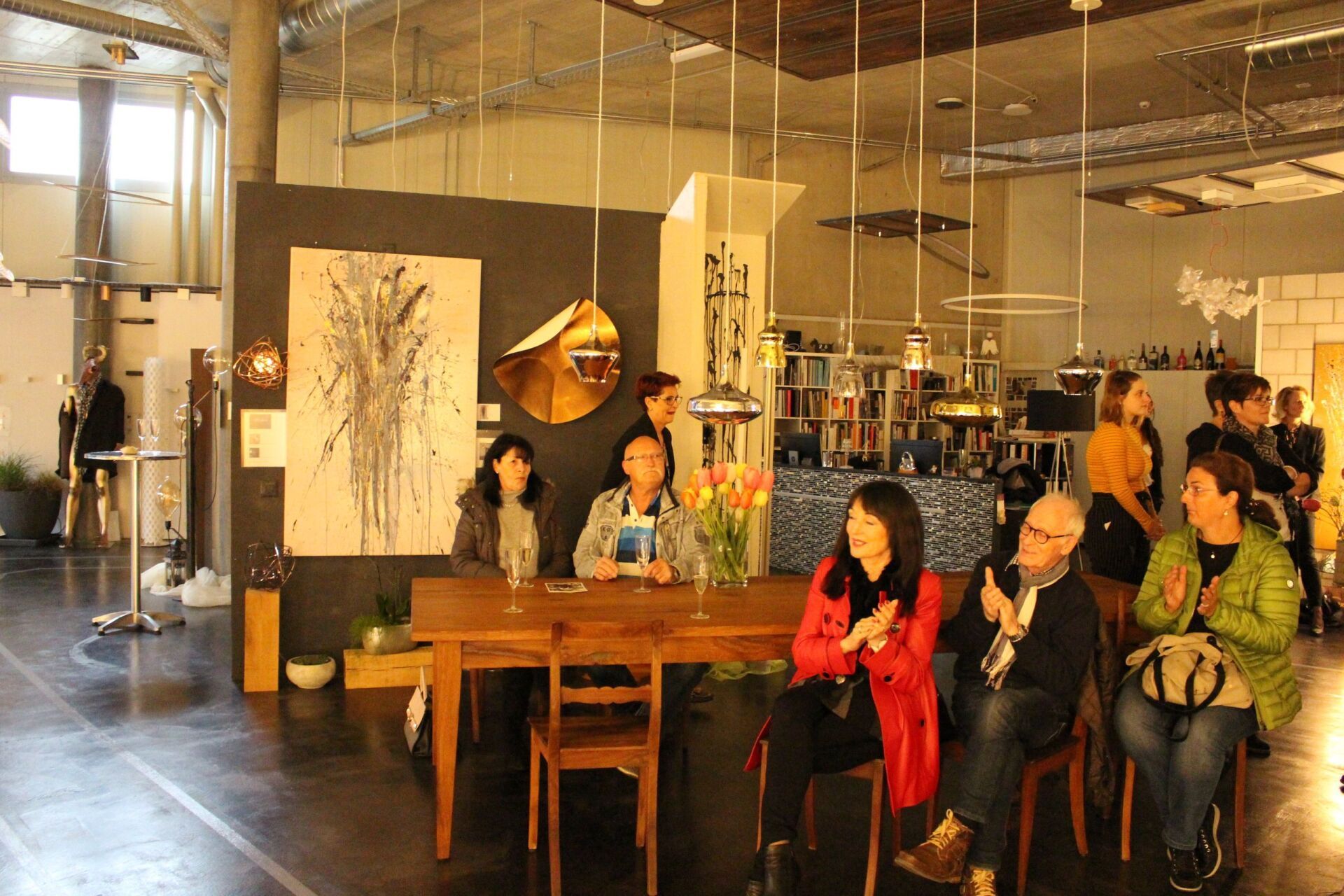 Eine Gruppe von Menschen sitzt in einem Raum um einen Tisch herum