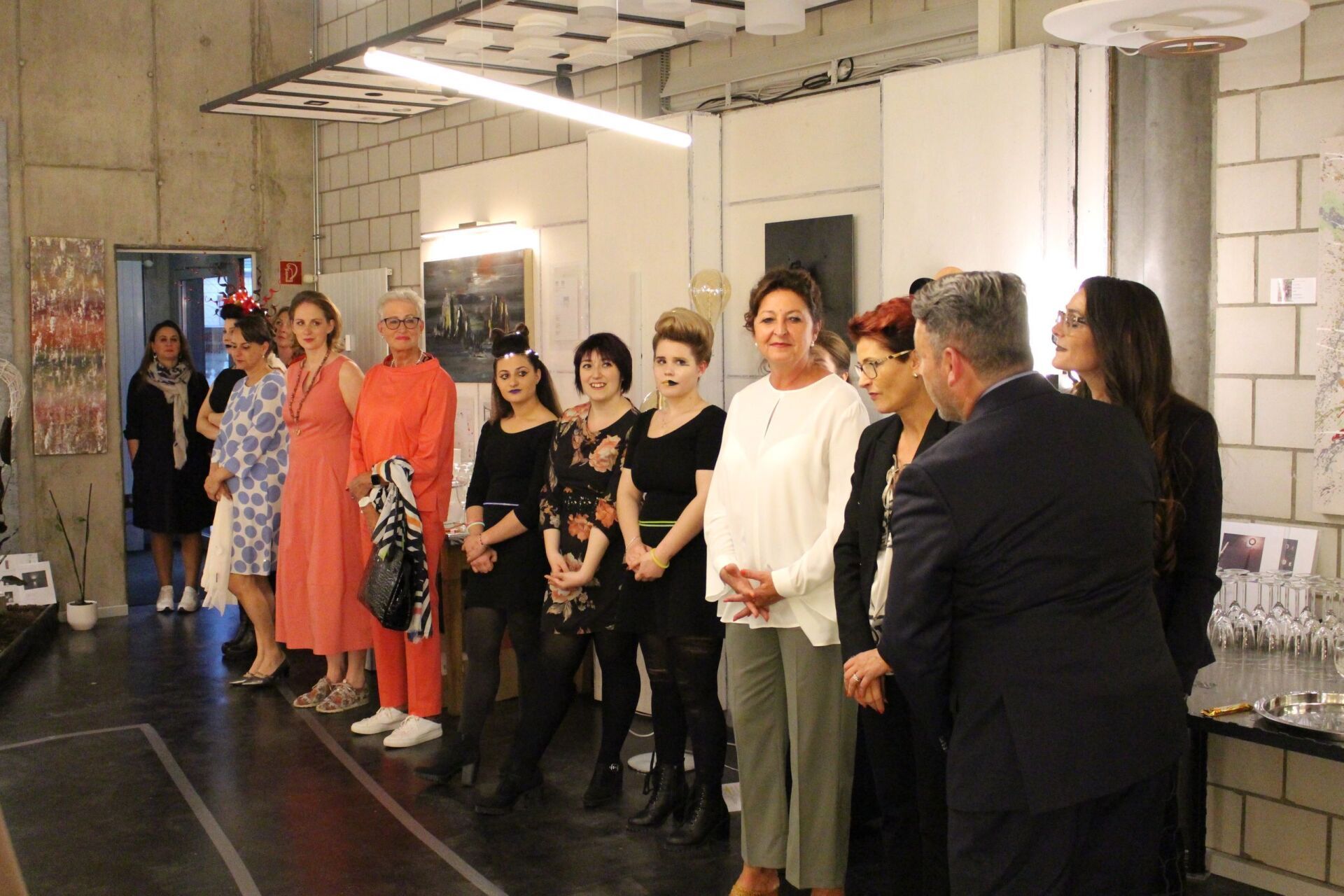 Eine Gruppe von Menschen, die nebeneinander in einem Raum stehen.