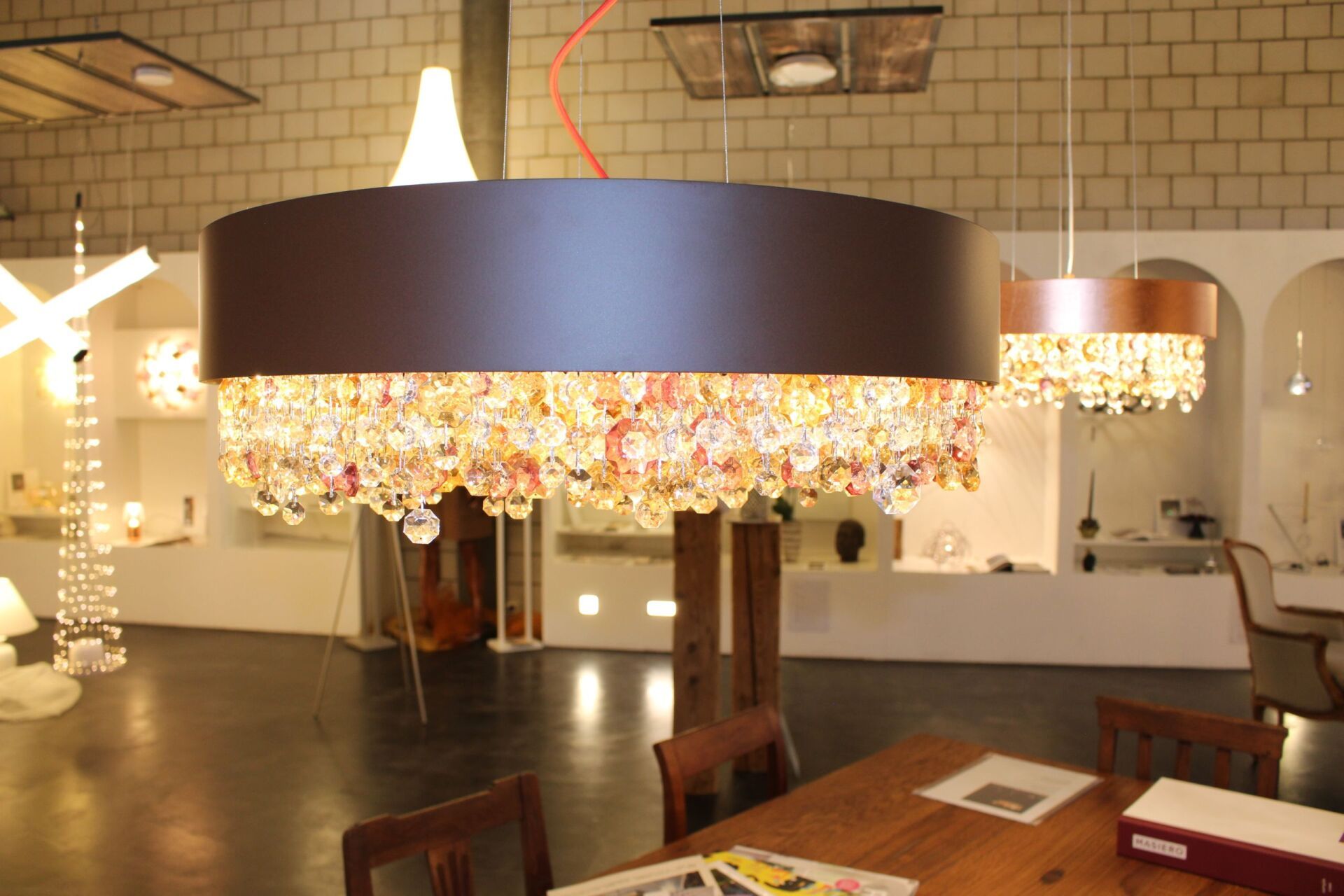 Ein Raum mit einem Tisch und Stühlen und einem Kronleuchter, der von der Decke hängt