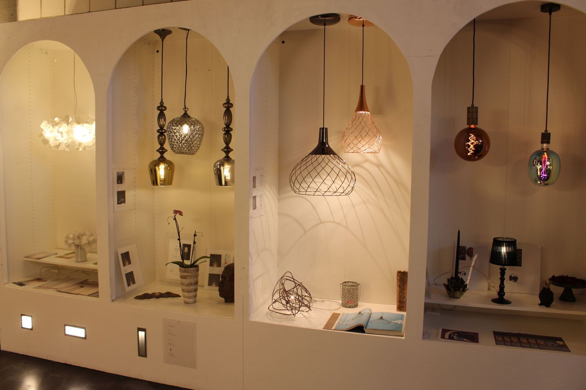 In diesem Raum hängen viele verschiedene Arten von Lampen von der Decke.