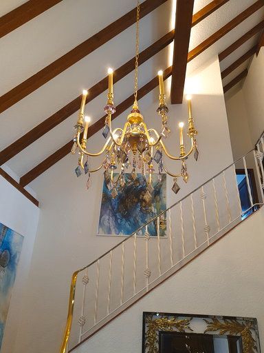 Über einer Treppe hängt ein Kronleuchter von der Decke.