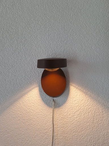 Ein Licht scheint auf eine weiße Wand.