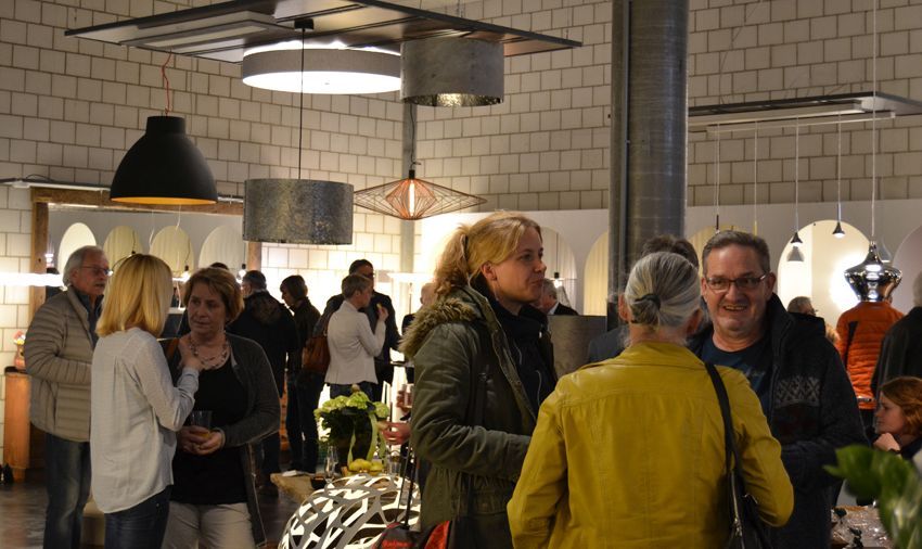 Eine Gruppe von Leuten steht in einem Raum und unterhält sich.