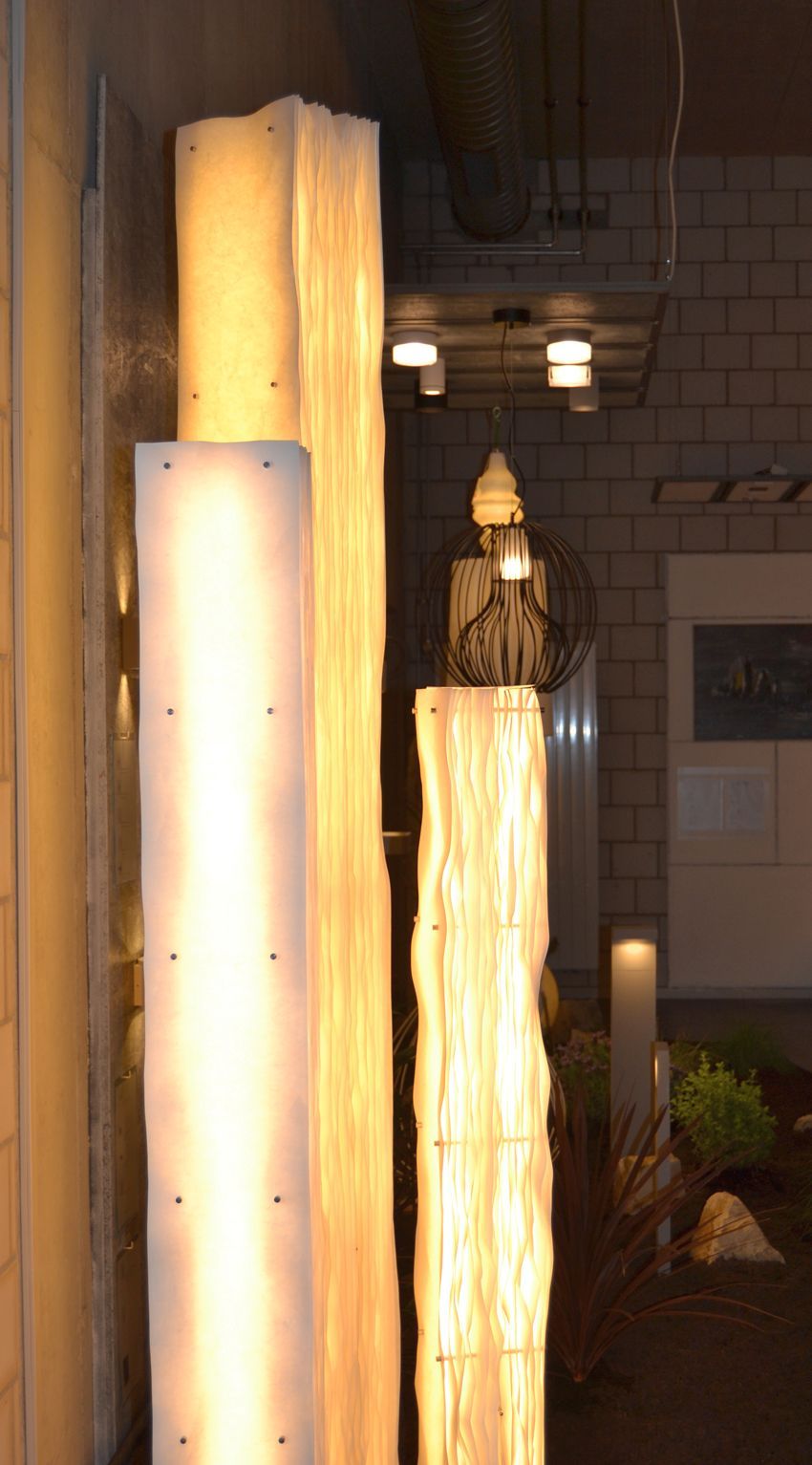 Eine Reihe hoher Lampen leuchten in einem Raum