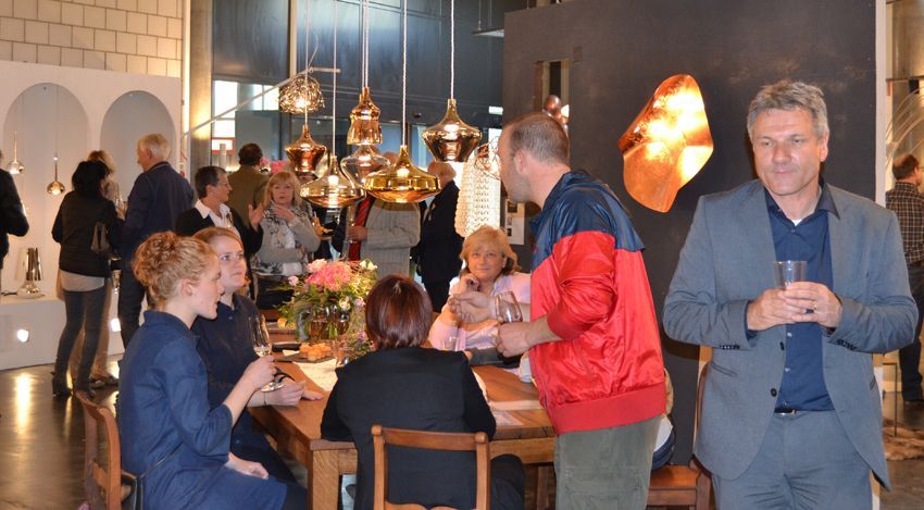 Eine Gruppe von Leuten steht in einem Raum um einen Tisch herum.