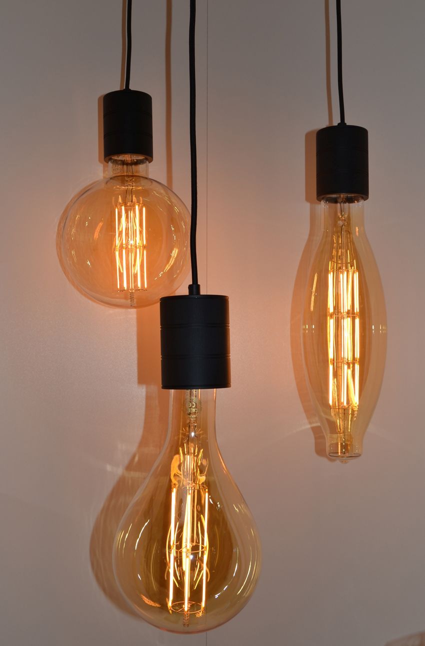 Drei Glühbirnen hängen an einem schwarzen Kabel