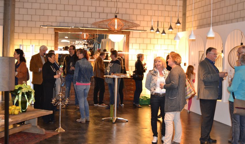 Eine Gruppe von Leuten steht in einem Raum und unterhält sich.