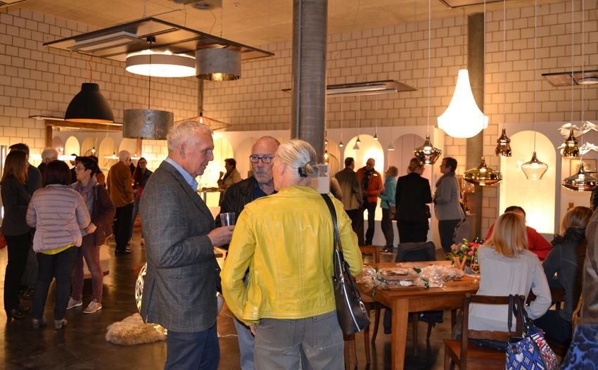 Eine Gruppe von Menschen steht in einem Raum und unterhält sich