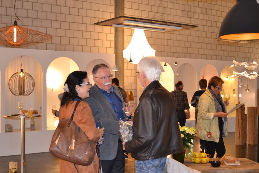 Eine Gruppe von Leuten steht in einem Raum und unterhält sich.