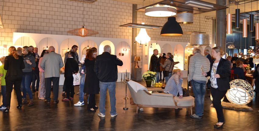 Eine Gruppe von Menschen steht in einem Raum um ein Sofa herum