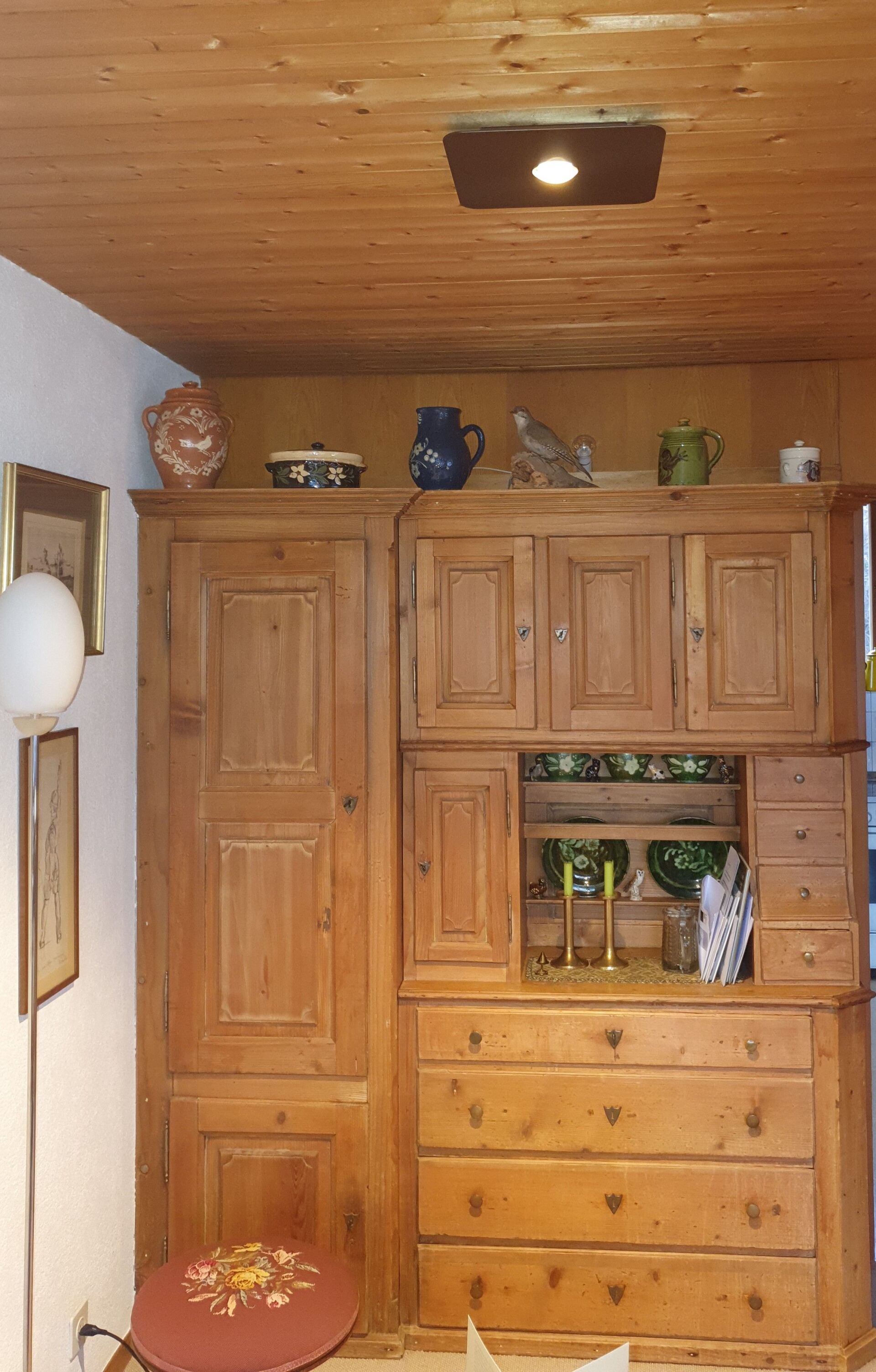 Ein Zimmer mit Holzschränken und Schubladen und einer Lampe