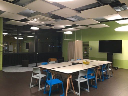 Ein Konferenzraum mit einem langen Tisch und blauen Stühlen.