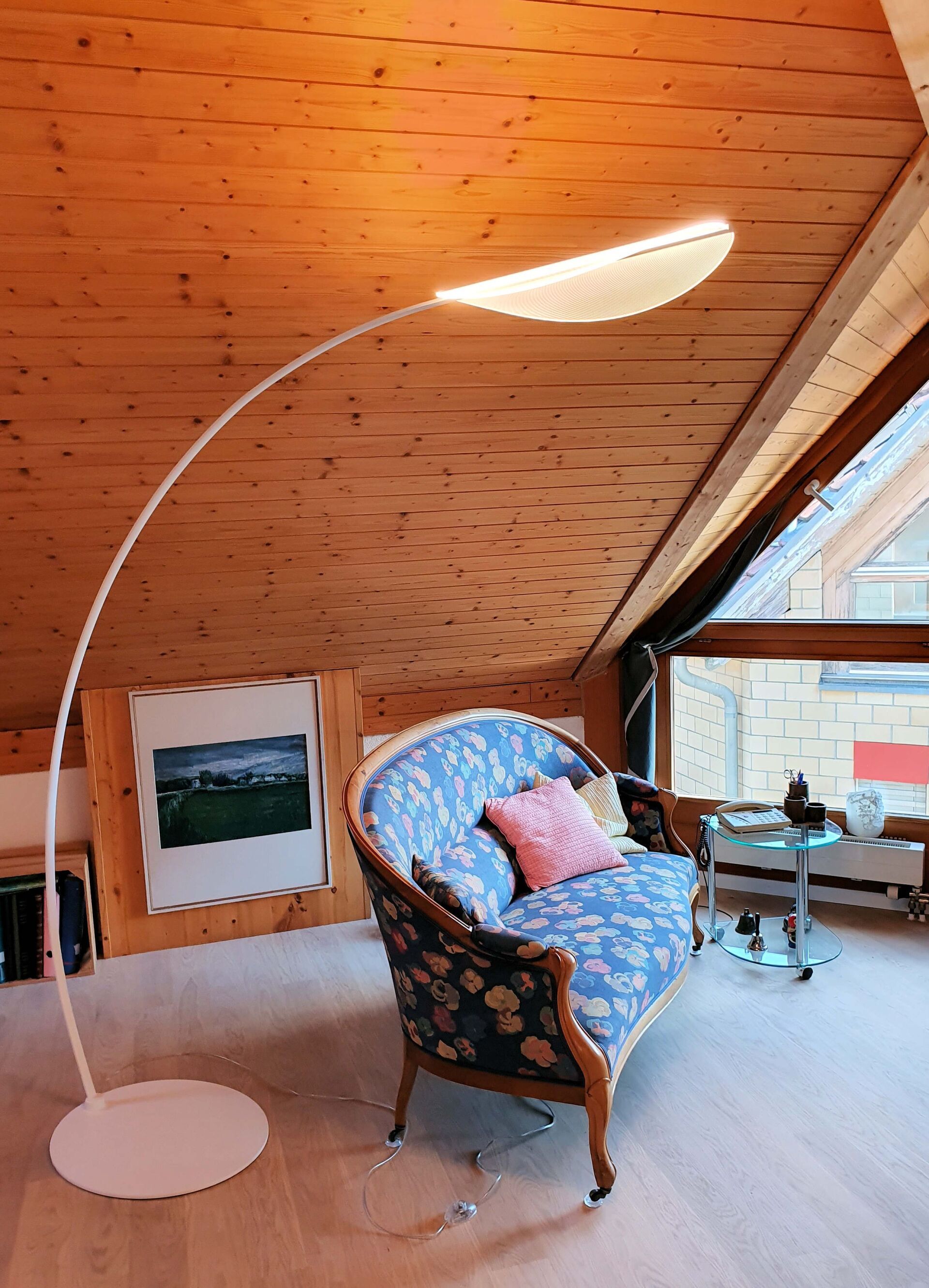 Ein Wohnzimmer mit einer Couch und einer Lampe.