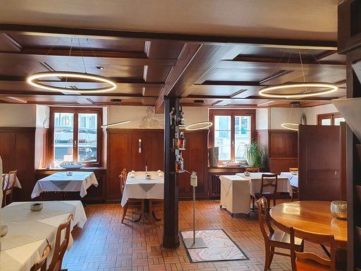 Ein großes Esszimmer mit Tischen und Stühlen.