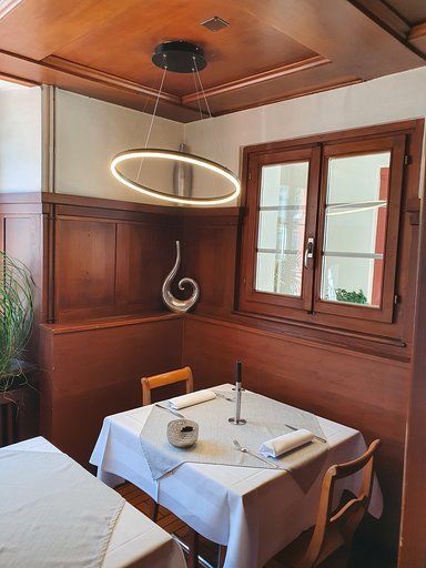 Ein Esszimmer mit Tisch und Stühlen und einem Fenster.