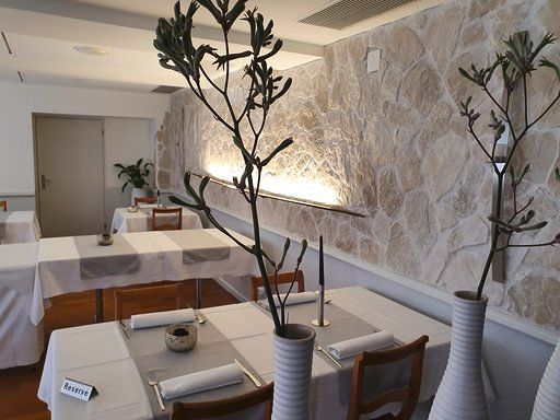 Ein Restaurant mit Tischen und Stühlen und Vasen mit Pflanzen darauf.