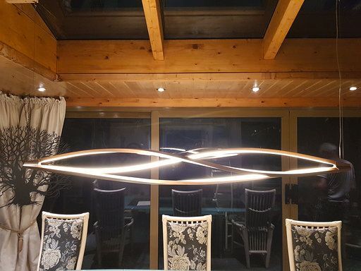 Ein Esszimmer mit einem Tisch und Stühlen und einer Lampe, die von der Decke hängt.