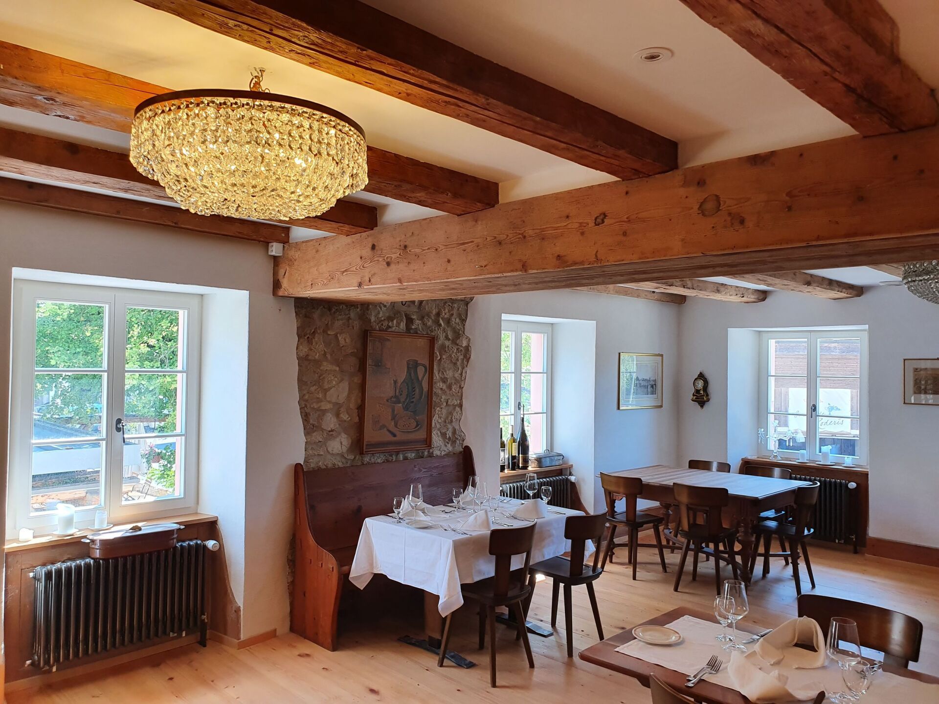 Ein Esszimmer mit Tischen und Stühlen und einem Kronleuchter, der von der Decke hängt.