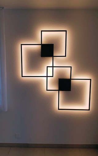 An einer Wand hängt eine Wandleuchte mit Quadraten.